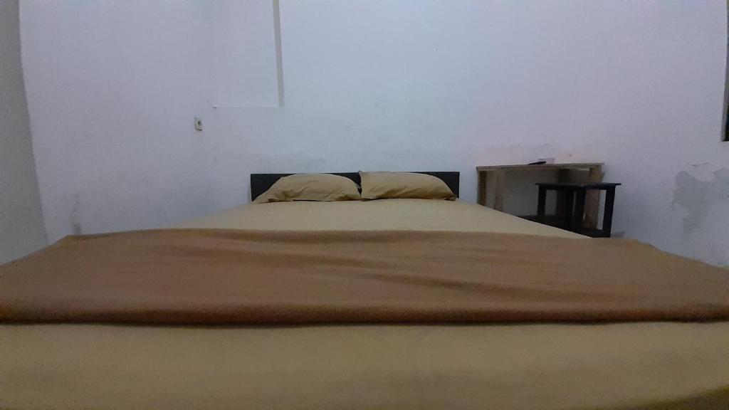 1 dormitorio con 2 almohadas en Rumah Rahman Syari'ah, en Bekasi