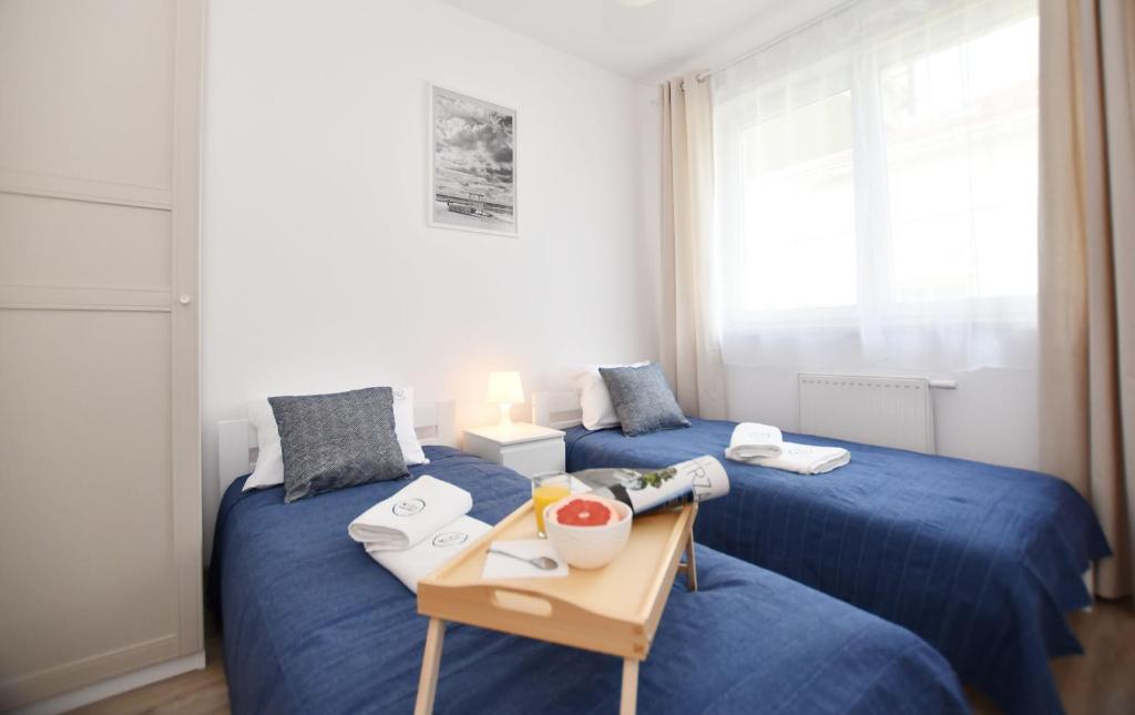 吉波瓦的住宿－MIZU Apartamenty - Bałtyk，一间设有两张床和一张桌子的房间