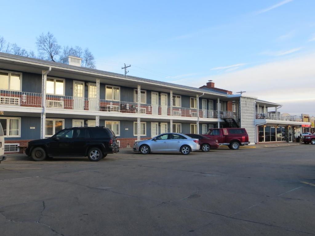 eine Gruppe von Autos, die vor einem Gebäude geparkt sind in der Unterkunft Midtown Western Inn - Kearney in Kearney