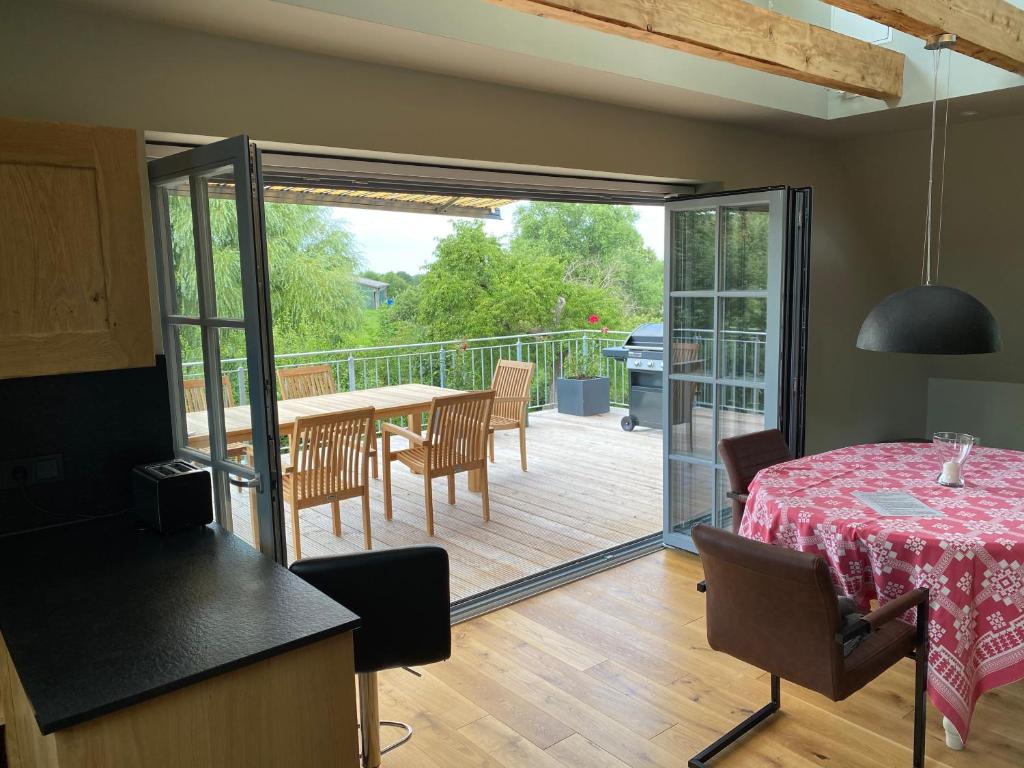 a kitchen and dining room with a table and a patio at Traumblick@ Baltic-Chalets in Kalkhorst