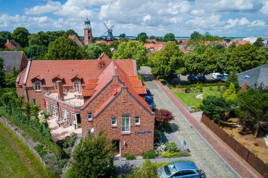 einen Luftblick auf ein großes Backsteinhaus mit einer Straße in der Unterkunft Hotel am Fischerhafen in Ditzum