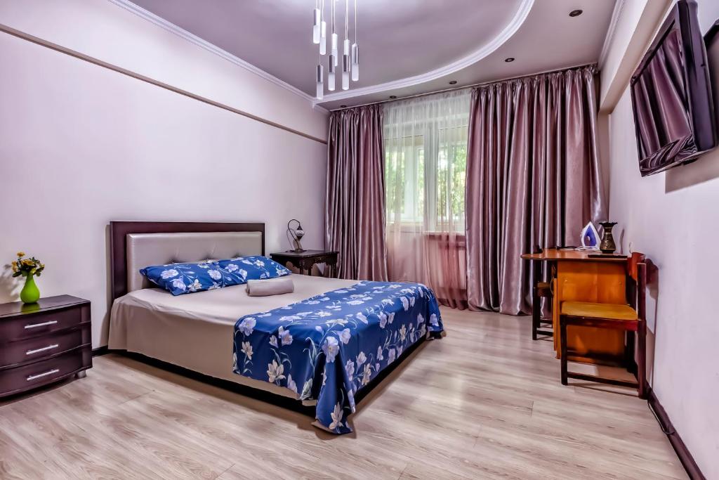 a bedroom with a bed and a dresser and a desk at 435 Апартаменты в центре для командированных и туристов in Almaty