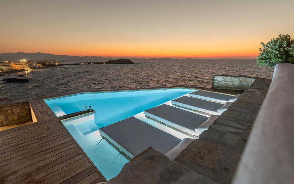 a swimming pool with a view of the ocean at Iliada Suites in Naxos Chora