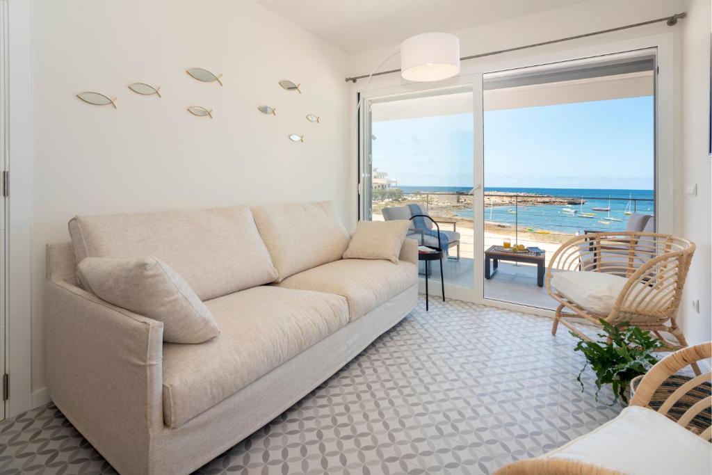 ein Wohnzimmer mit Couch und Blick aufs Meer in der Unterkunft BLAU Apartamento en Cala Galiota con vistas al mar in Colonia Sant Jordi