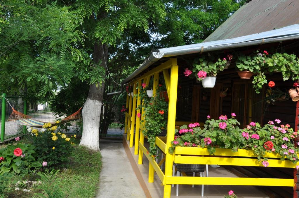 a yellow house with flowers on the side of it at Pensiunea Rustic in Eforie Sud