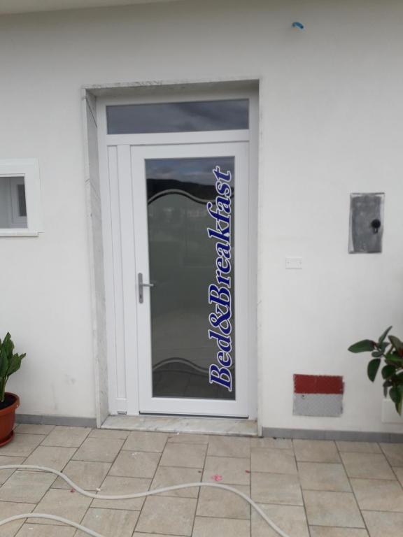 a white door with a blue sign on it at Raggio di sole in Rocca Imperiale
