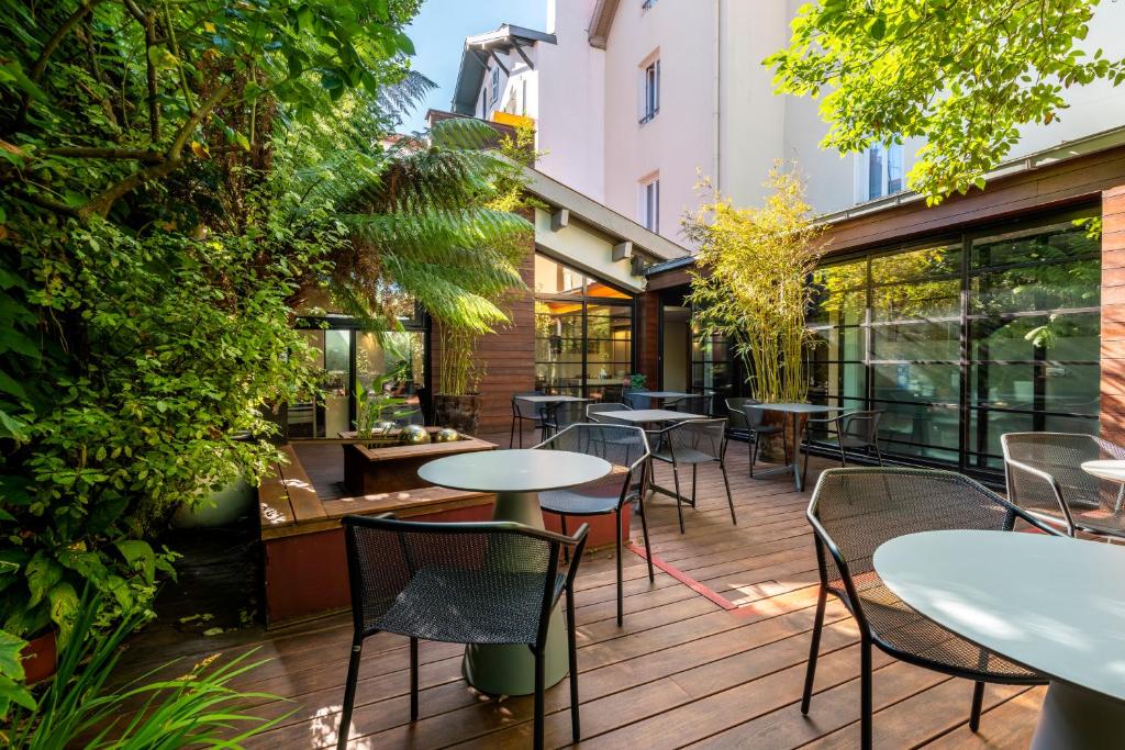 un patio extérieur avec des tables, des chaises et des plantes dans l'établissement Hotel Villa Koegui Biarritz, à Biarritz