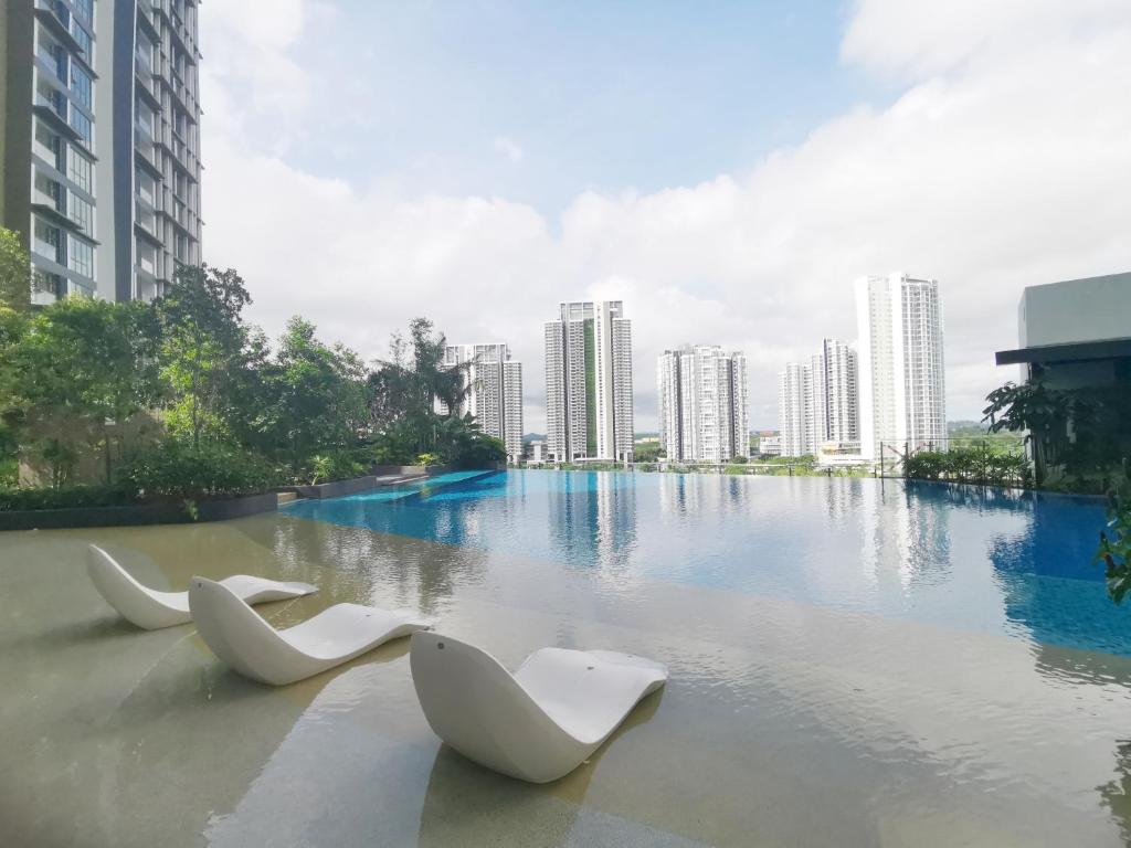 two white chairs sitting in the middle of a body of water at The Elysia Park Residence by Home Owner in Johor Bahru