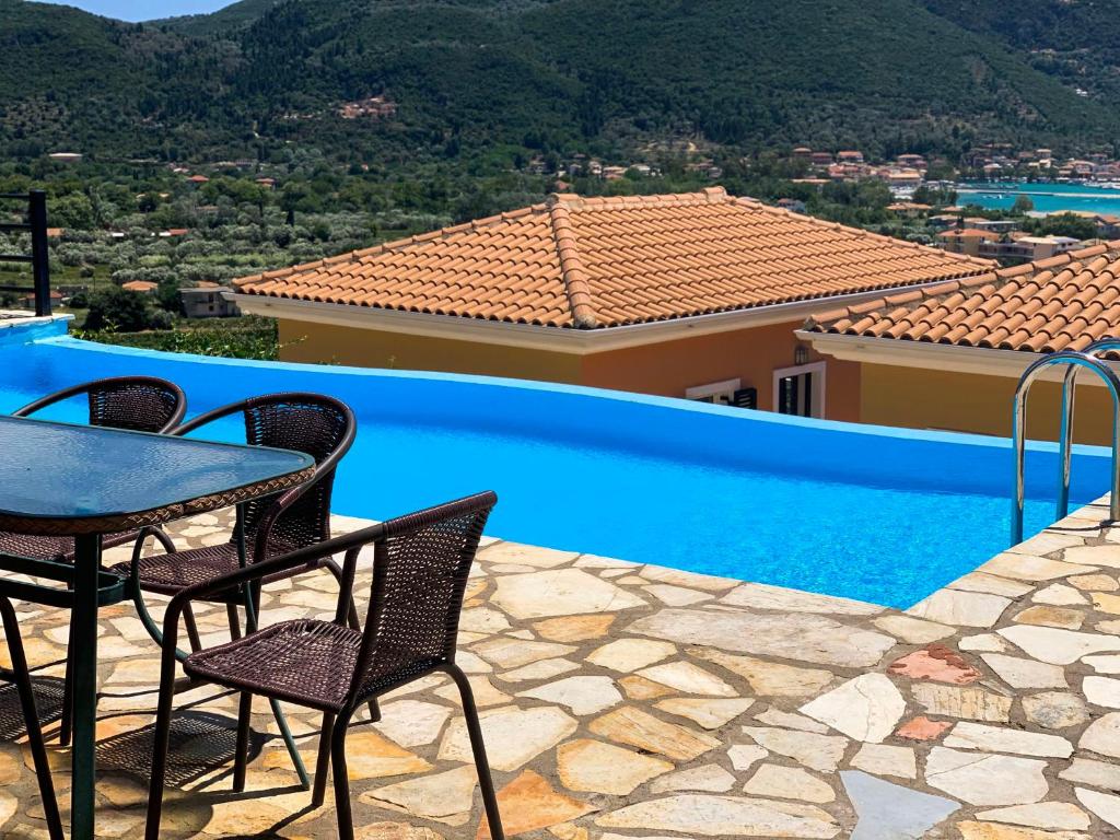 a patio with a table and chairs next to a swimming pool at Aegli in Vasiliki