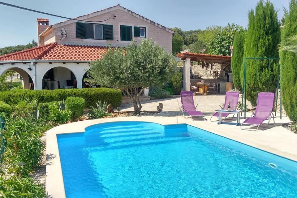 uma villa com uma piscina e uma casa em Charming Villa Nika with the pool em Supetar