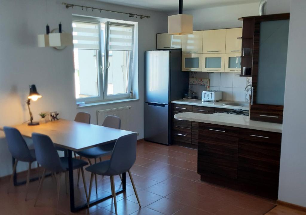 cocina con mesa y nevera azul en Apartament dwupoziomowy, en Augustów