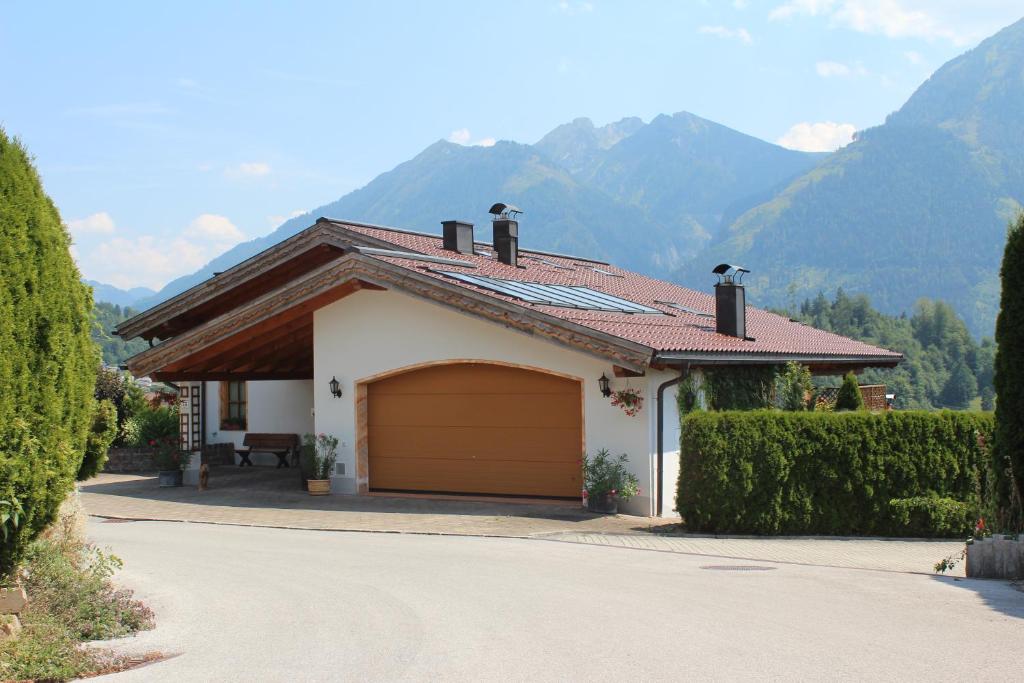 a house with a garage with mountains in the background at Ferienwohnung Alpenrose in Goldegg