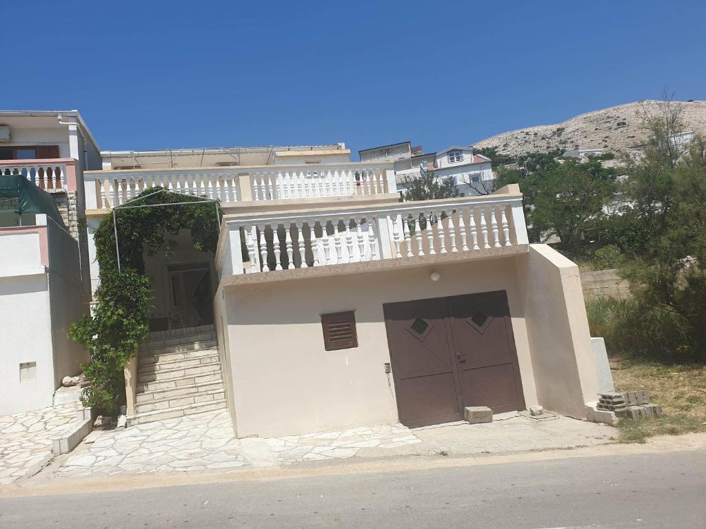 a white house with a balcony on top of it at Tonica Put rive 17 in Metajna