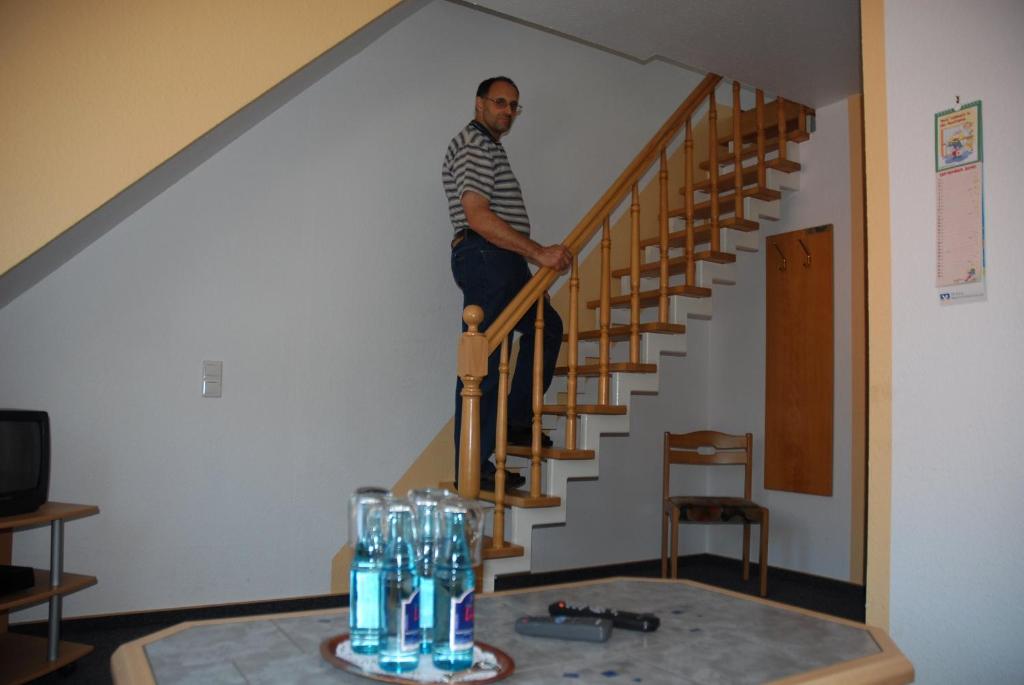 a man standing on the stairs in a house at Ferienhof & Café Schnieder in Dülmen