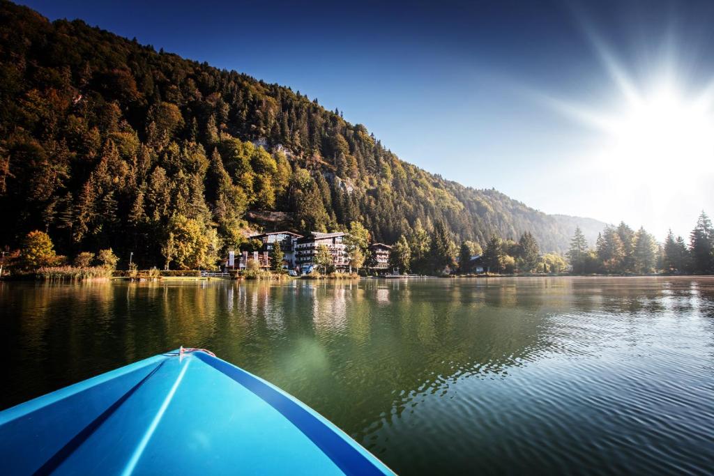 a boat on a lake in front of a mountain at Seehotel Brunner in Walchsee