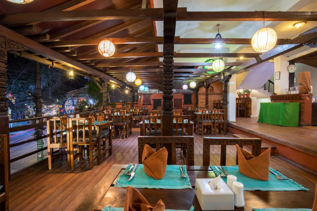 un ristorante con tavoli e sedie in legno e luci di Landmark Pokhara a Pokhara