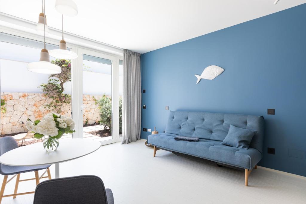 a blue living room with a blue couch and a table at Santa Caterina - Dimora sul mare in Polignano a Mare
