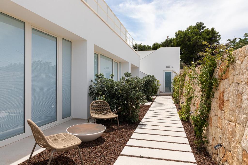 a garden with two chairs and a table on the side of a building at Santa Caterina - Dimora sul mare in Polignano a Mare