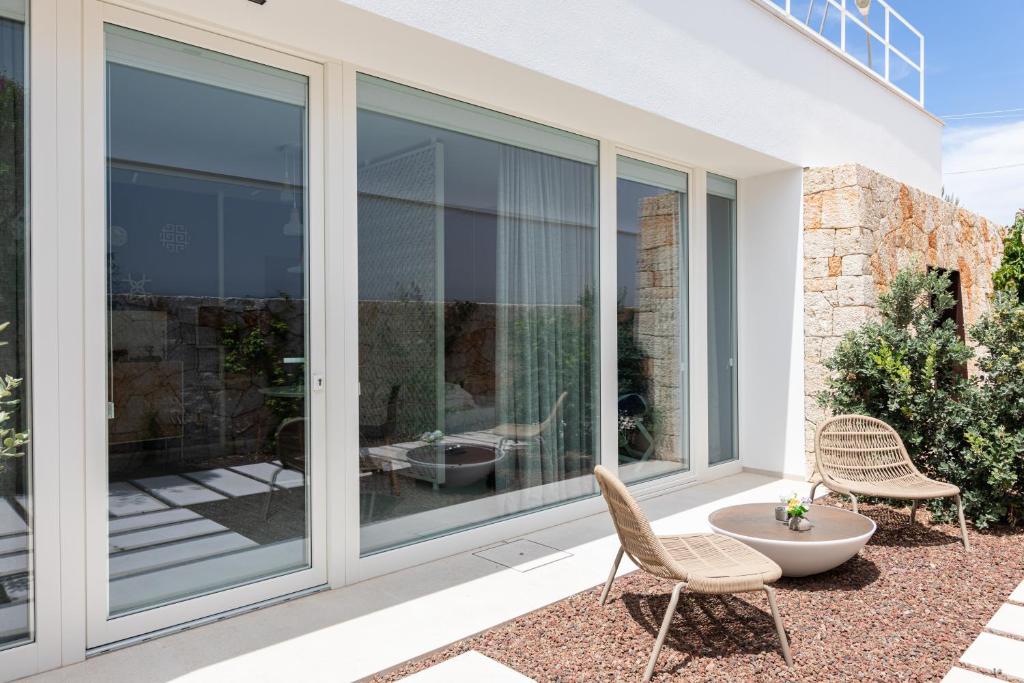 a glass extension of a house with chairs and a table at Santa Caterina - Dimora sul mare in Polignano a Mare