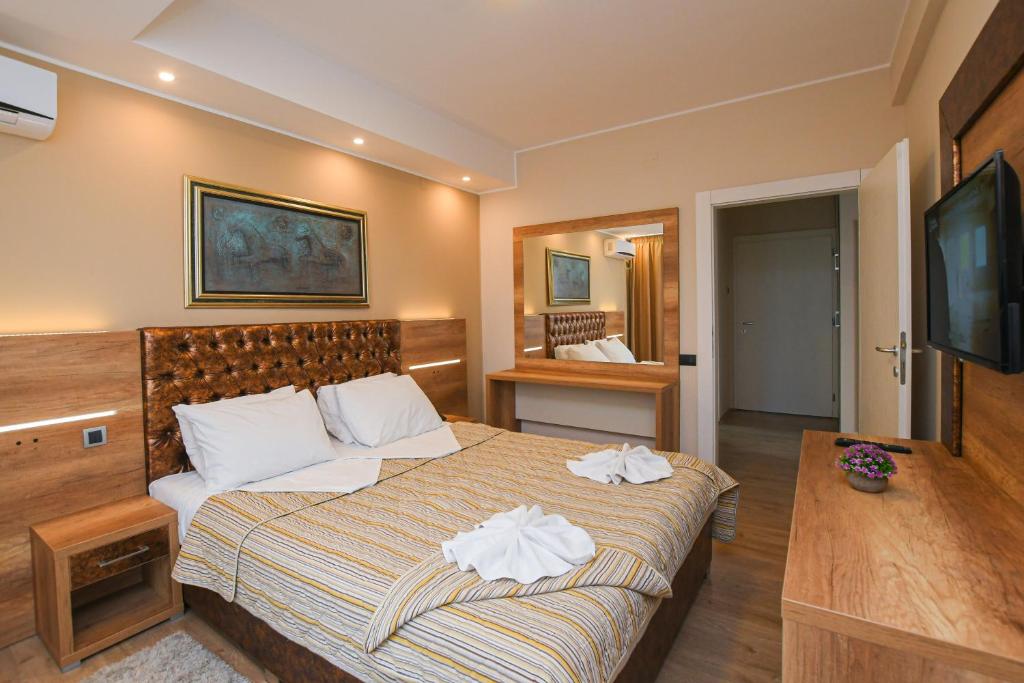 a hotel room with a bed and a dresser at Hotel Djerdap in Kladovo