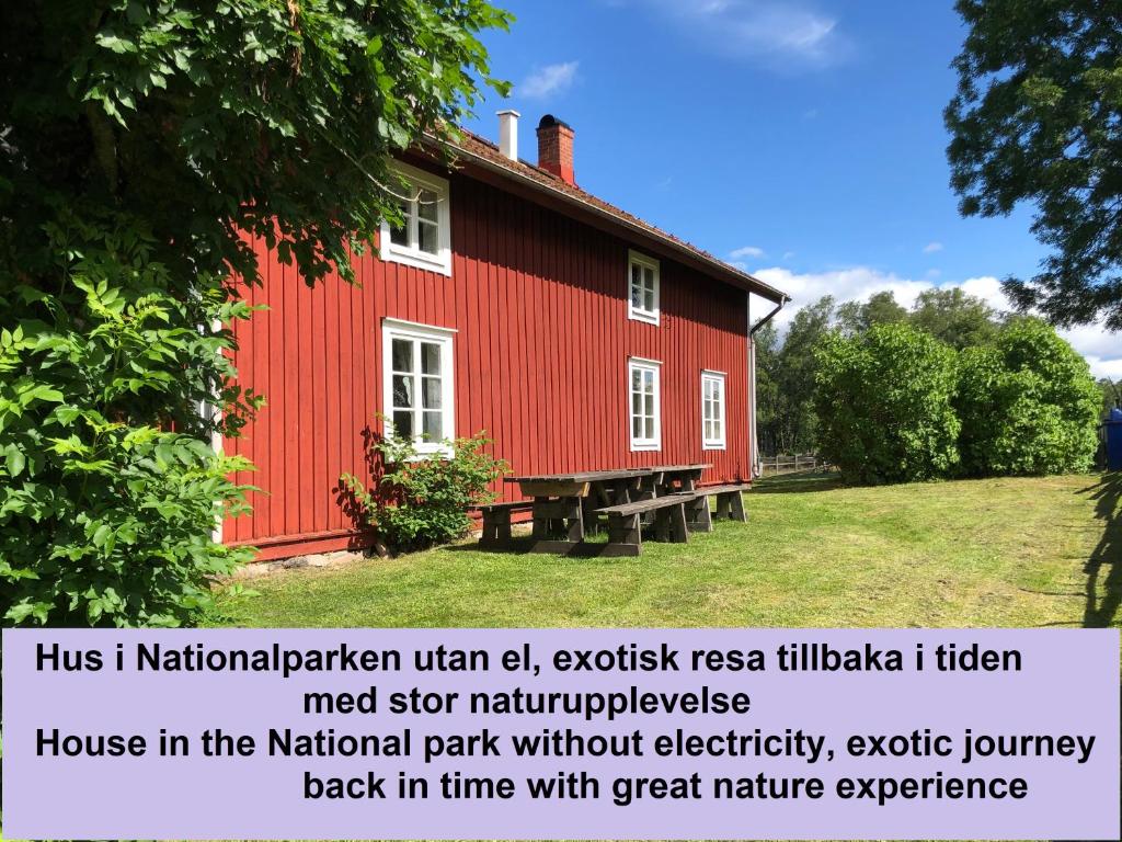 a red house with a sign in front of it at Vandrarhem Lövö in Hillerstorp