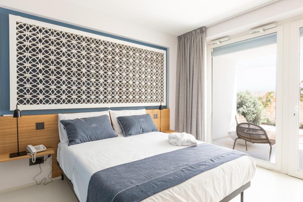 a bedroom with a large bed and a large window at Santa Caterina - Dimora sul mare in Polignano a Mare