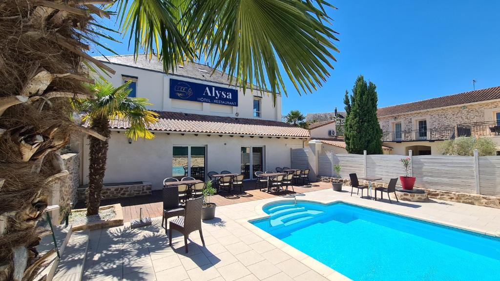 a hotel with a swimming pool in front of a building at ALYSA in Parthenay