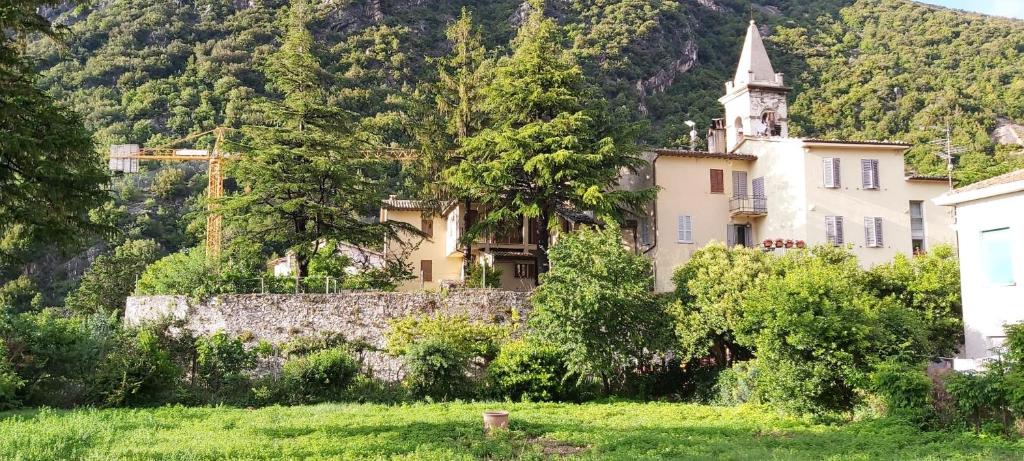 Casa vacanze I PINI E IL CILIEGIO في Pale: مبنى قديم مع كنيسة على جبل