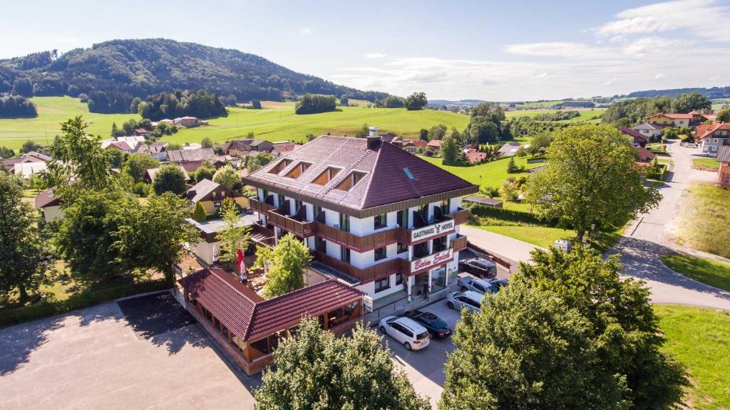 una vista aérea de una casa grande con coches aparcados delante en Gasthaus Hotel Beim Erich en Oberhofen am Irrsee