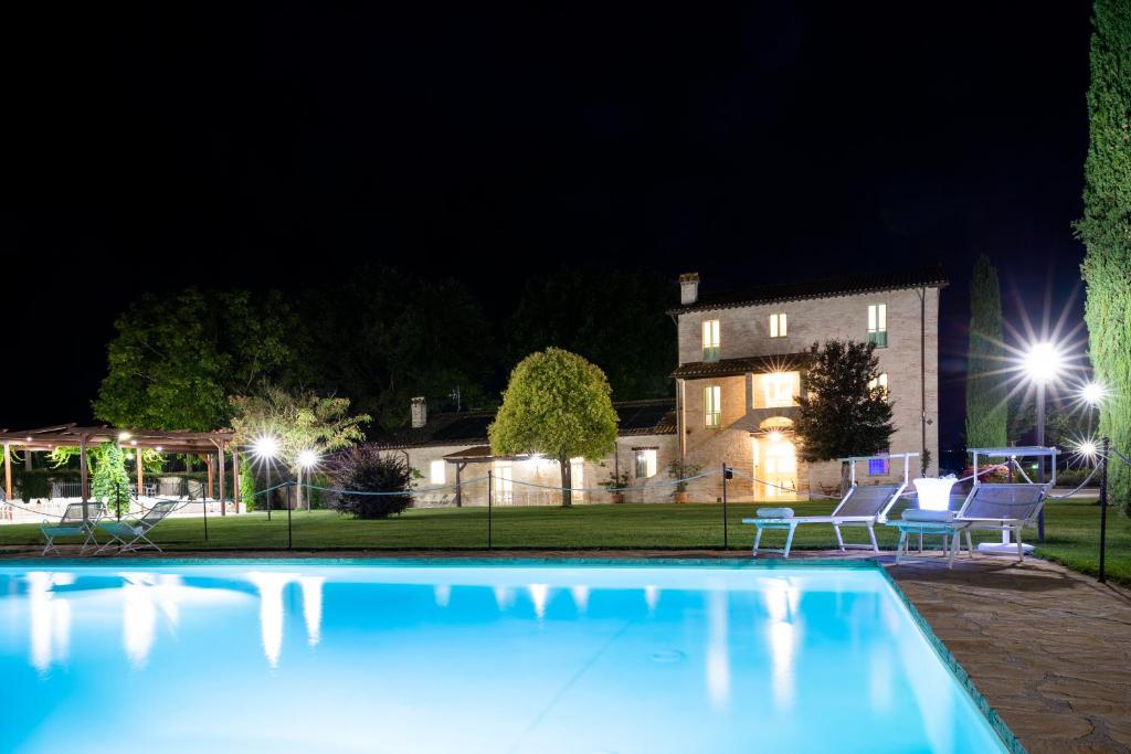 a swimming pool in front of a house at night at Demetra in Papiano