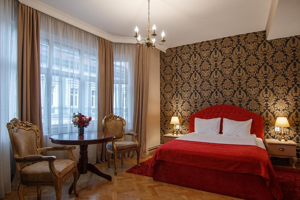 - une chambre avec un lit rouge et une table dans l'établissement Casa Monte Verde, à Braşov