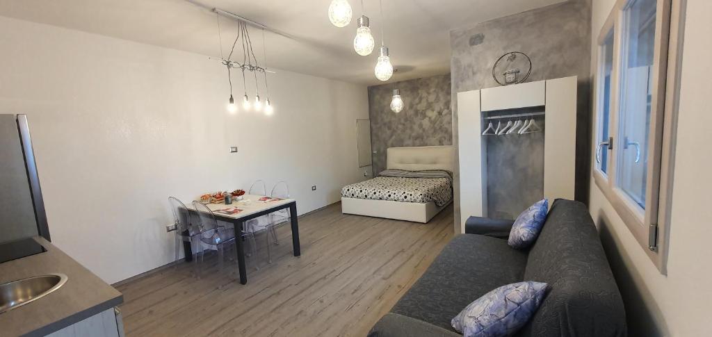 een woonkamer met een bank, een tafel en een bed bij La Casetta tra Sassi e Ulivi B&B in Matera