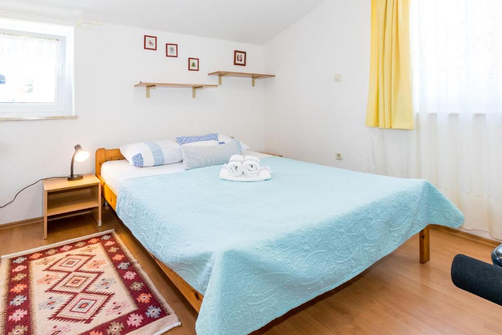 sypialnia z łóżkiem z niebieskim kocem w obiekcie Cozy apartments Emina near the sea w mieście Premantura