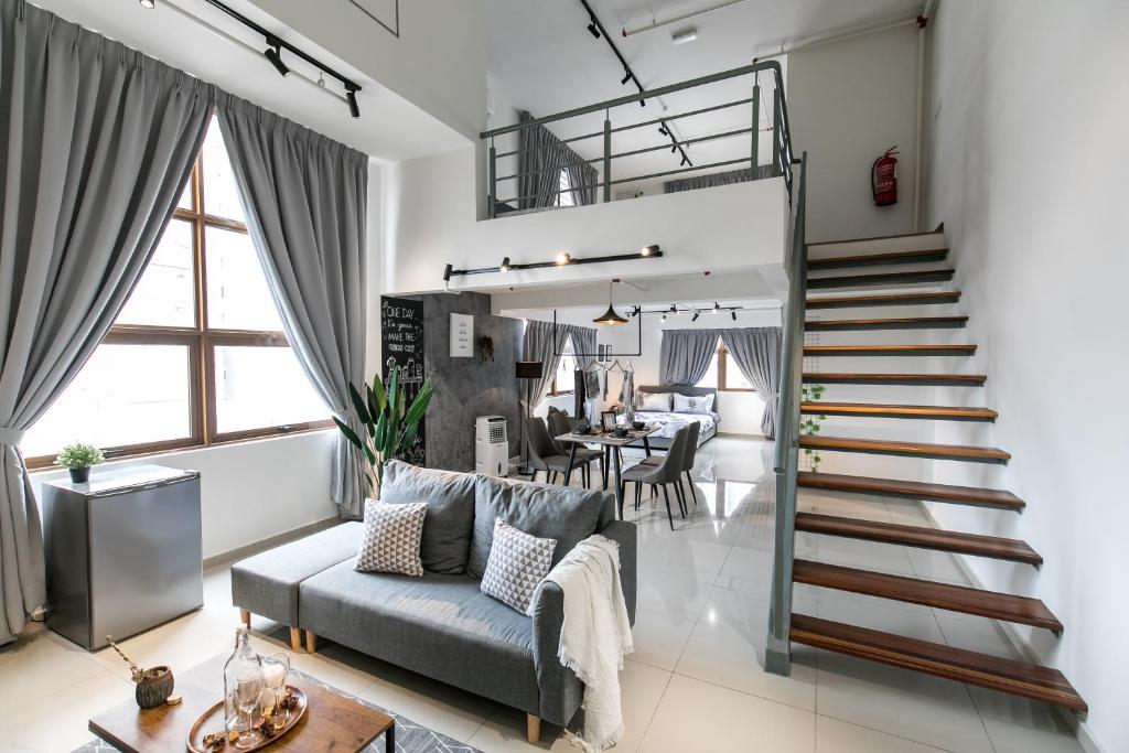 een woonkamer met een trap naar een eetkamer bij Pinnacle Duplex@6Pax-5m Walk to Paradigm Mall+WIFI in Petaling Jaya