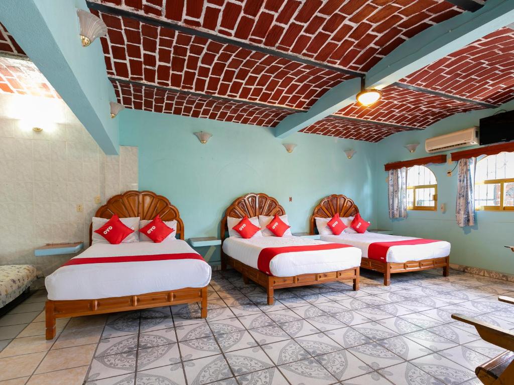 2 camas en una habitación con paredes azules en Hotel Posada Agua Escondida en Cihuatlán