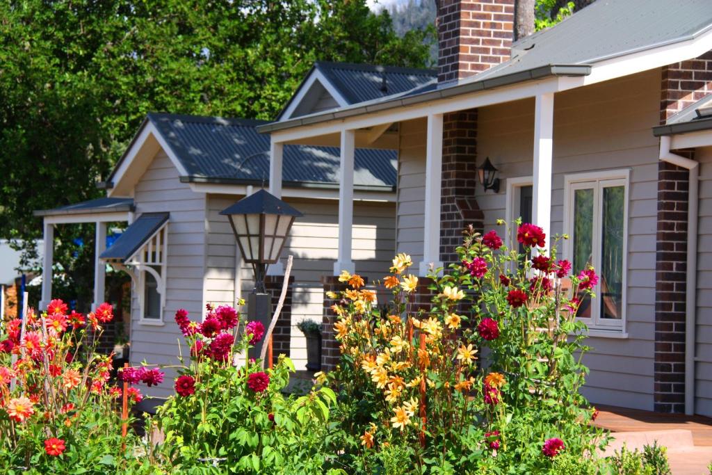 ein Haus mit Blumen im Vorgarten in der Unterkunft Marysville Garden Cottages in Marysville