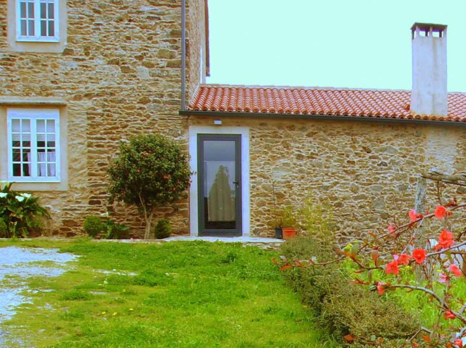 una casa de piedra con una puerta y un patio en Casa de campo a 10 min. de Santiago en Touro