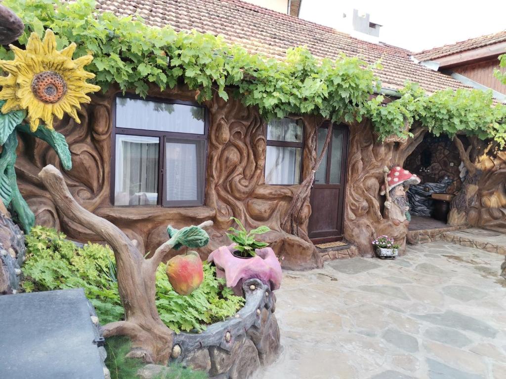 a house with a wooden facade with a sunflower at Хаджи Марковата къща за гости гр.Дряново in Dryanovo