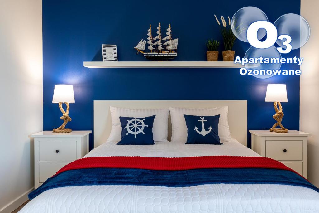a bedroom with a bed with blue walls and two lamps at Amare Apartments B1 in Mosty