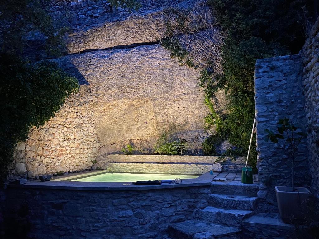 un mur en pierre avec une piscine au milieu dans l'établissement la bonbonniere - Townhouse Saint-Saturnin-lès-Apt, à Saint-Saturnin-lès-Apt