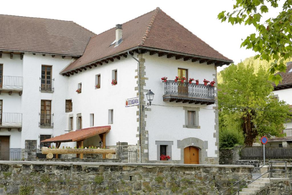 a large white building with a balcony on top at Aizkolarienea in Ochagavía