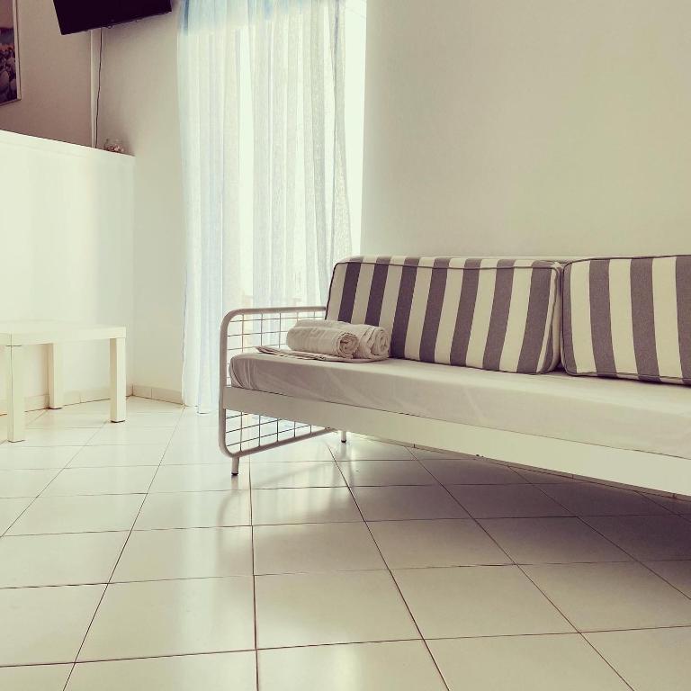 a couch sitting on a tiled floor in a room at Spanos Apartments in Agios Petros
