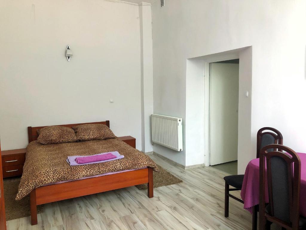 a bedroom with a bed with a pink towel on it at Hotel Kowalski in Mrągowo