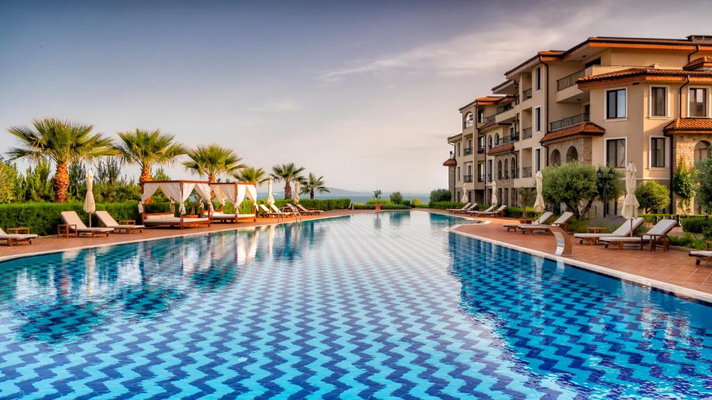 Burgas Beach Resort Apartments في مدينة بورغاس: مسبح كبير مع كراسي ومباني