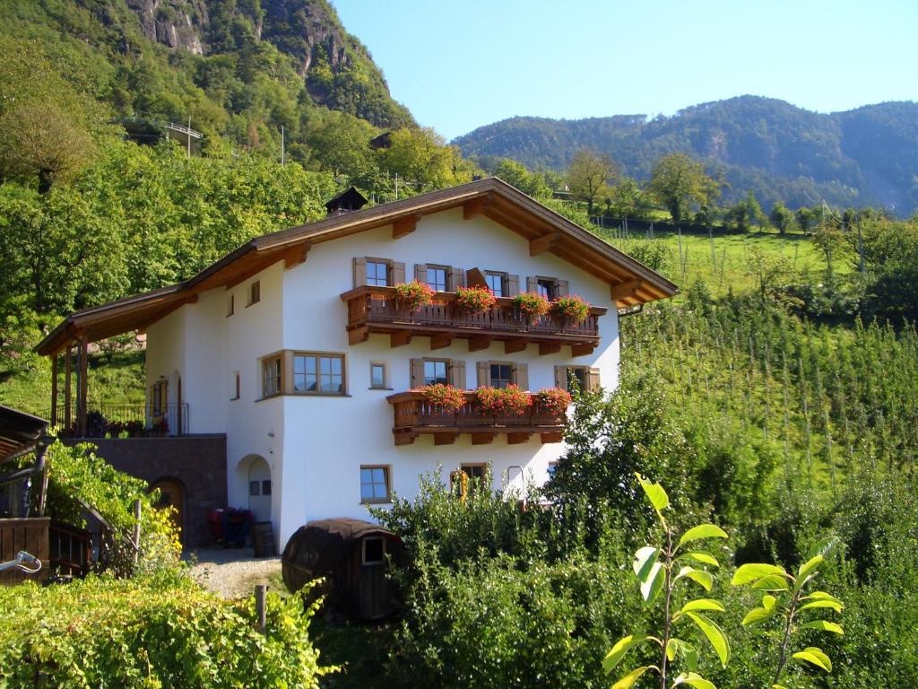 a white house with a balcony with flowers on it at Lafreiderhof in Castelrotto