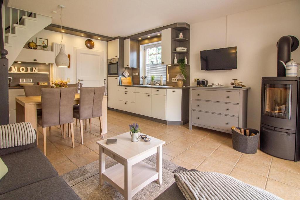 a living room with a kitchen and a dining room at Lüttje Scholle in Krummhörn