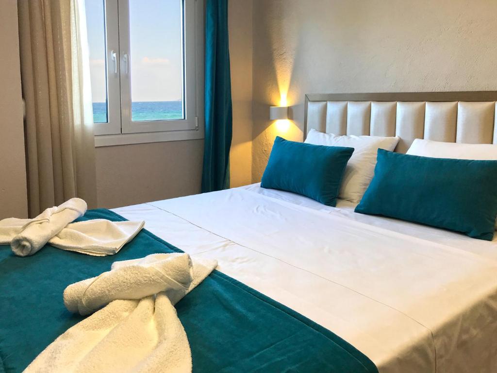 1 dormitorio con 1 cama grande con almohadas azules en Skoulidis Family Apartments, en Nea Vrasna