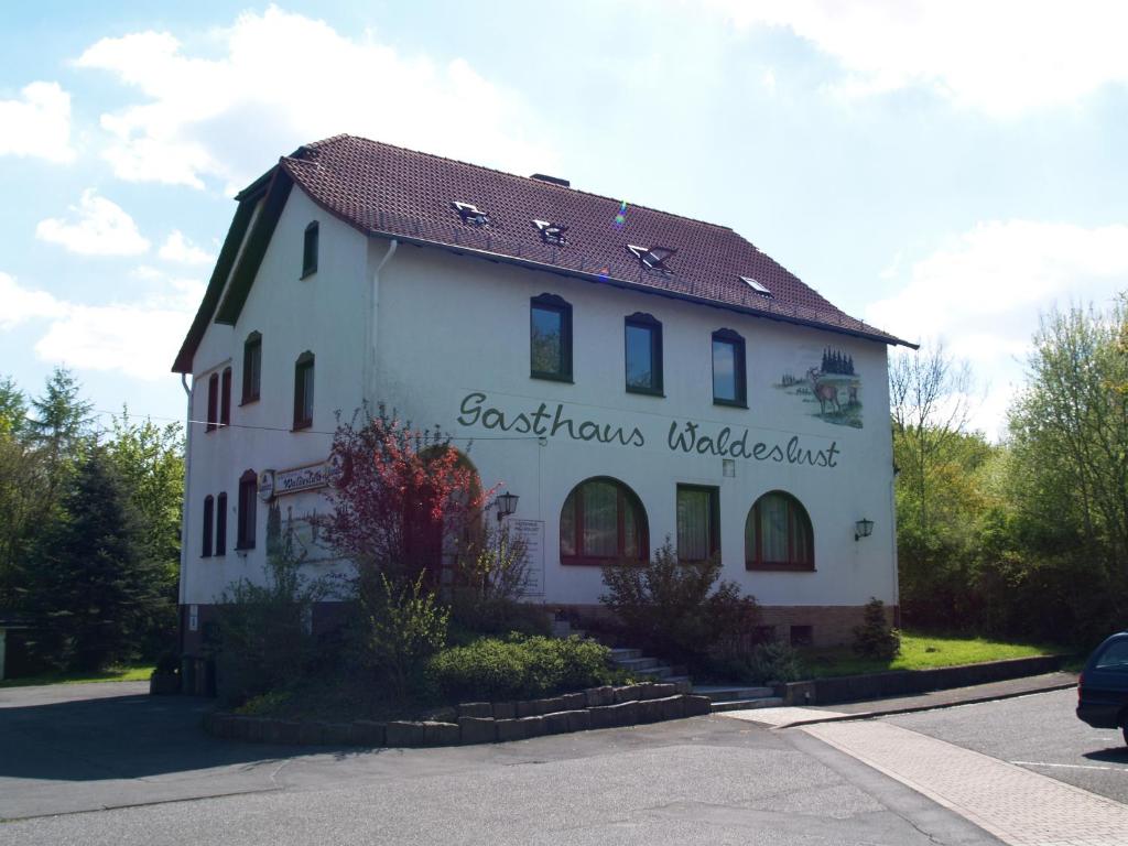a white building with a sign on the side of it at Gästehaus Waldeslust in Espenau