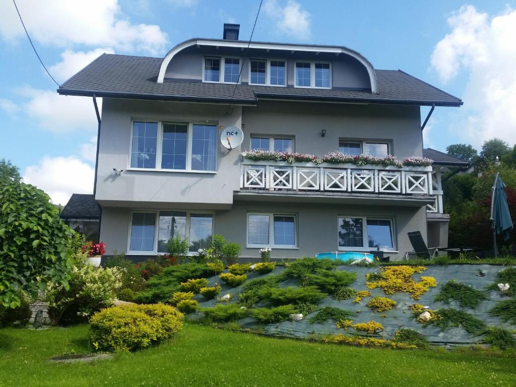 a house with a garden in front of it at Biały domek in Wisła