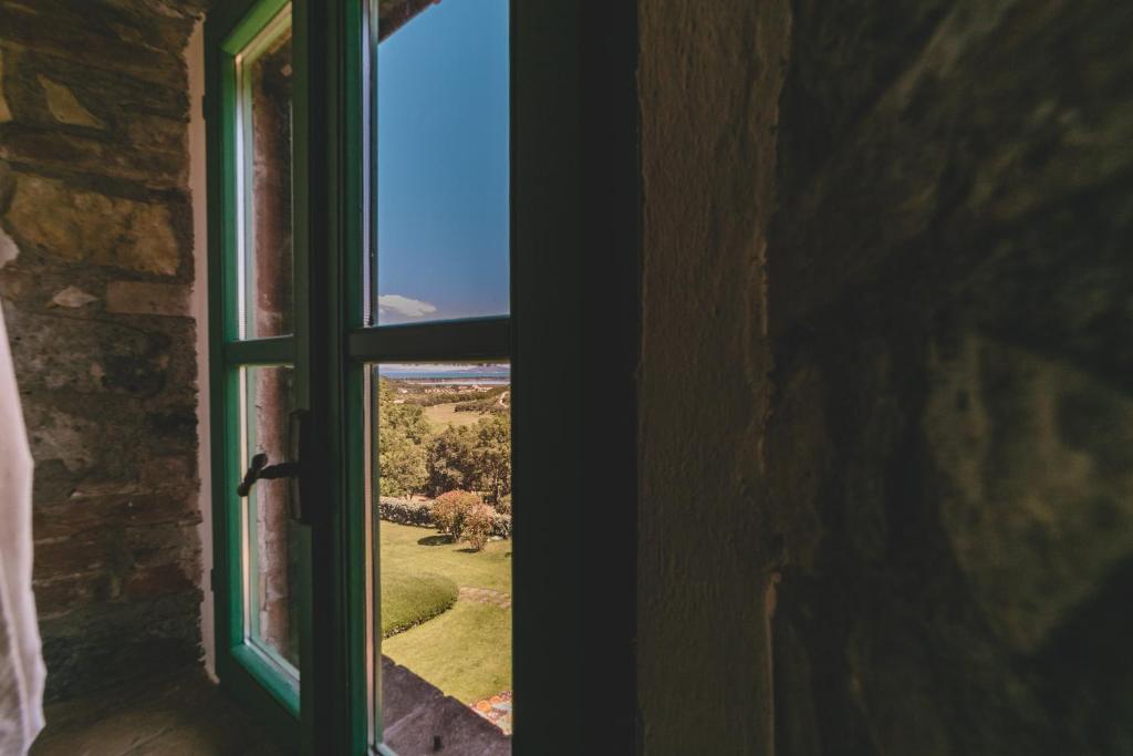 an open window with a view of a garden at Country Relais La Mortella in Porto Ercole